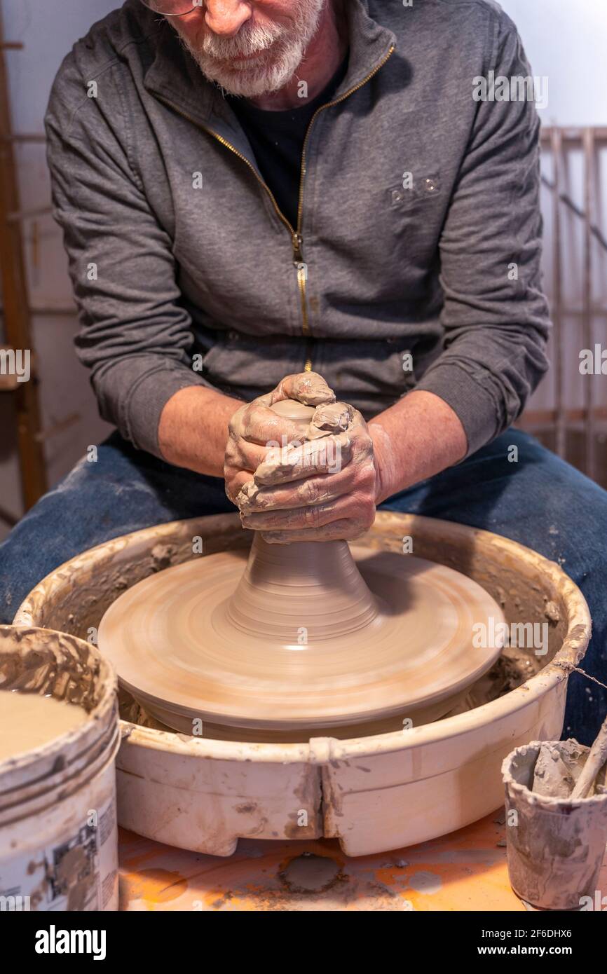 pottery craftsman working on a potters wheel to make a new bowl Stock