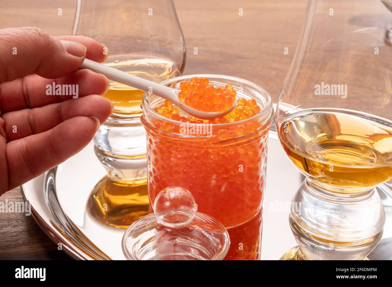Pairing of single malt scotch or japanese whisky and high quality red trout fish caviar in glass jar Stock Photo