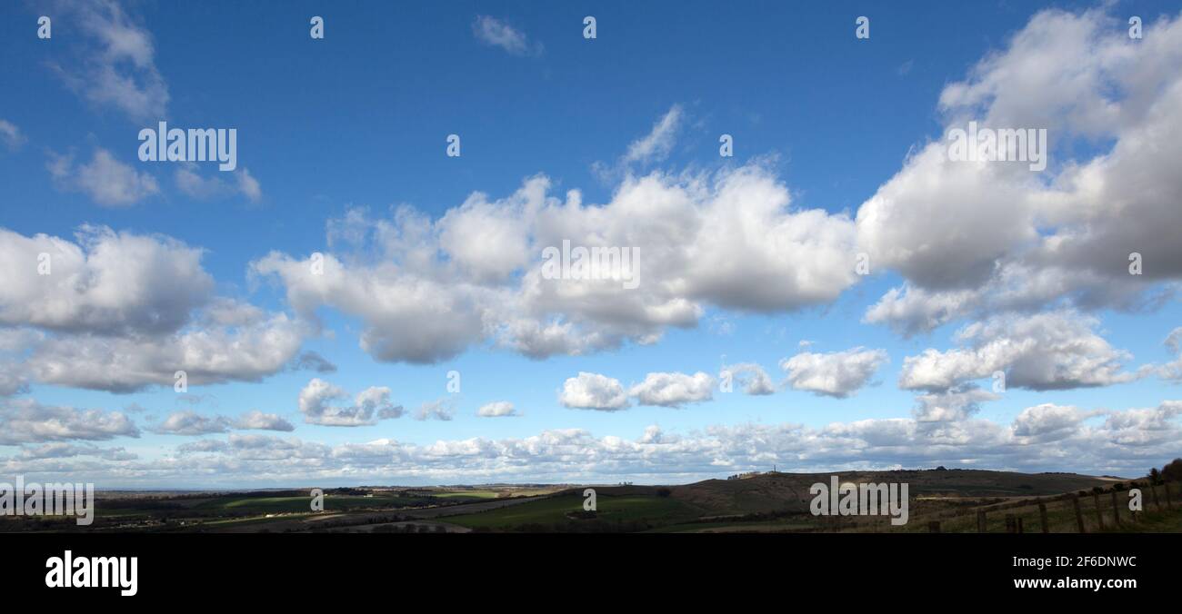 Lines of cumulus clouds in blue sky passing over chalk downland, Cherhill, Wiltshire, England, UK Stock Photo