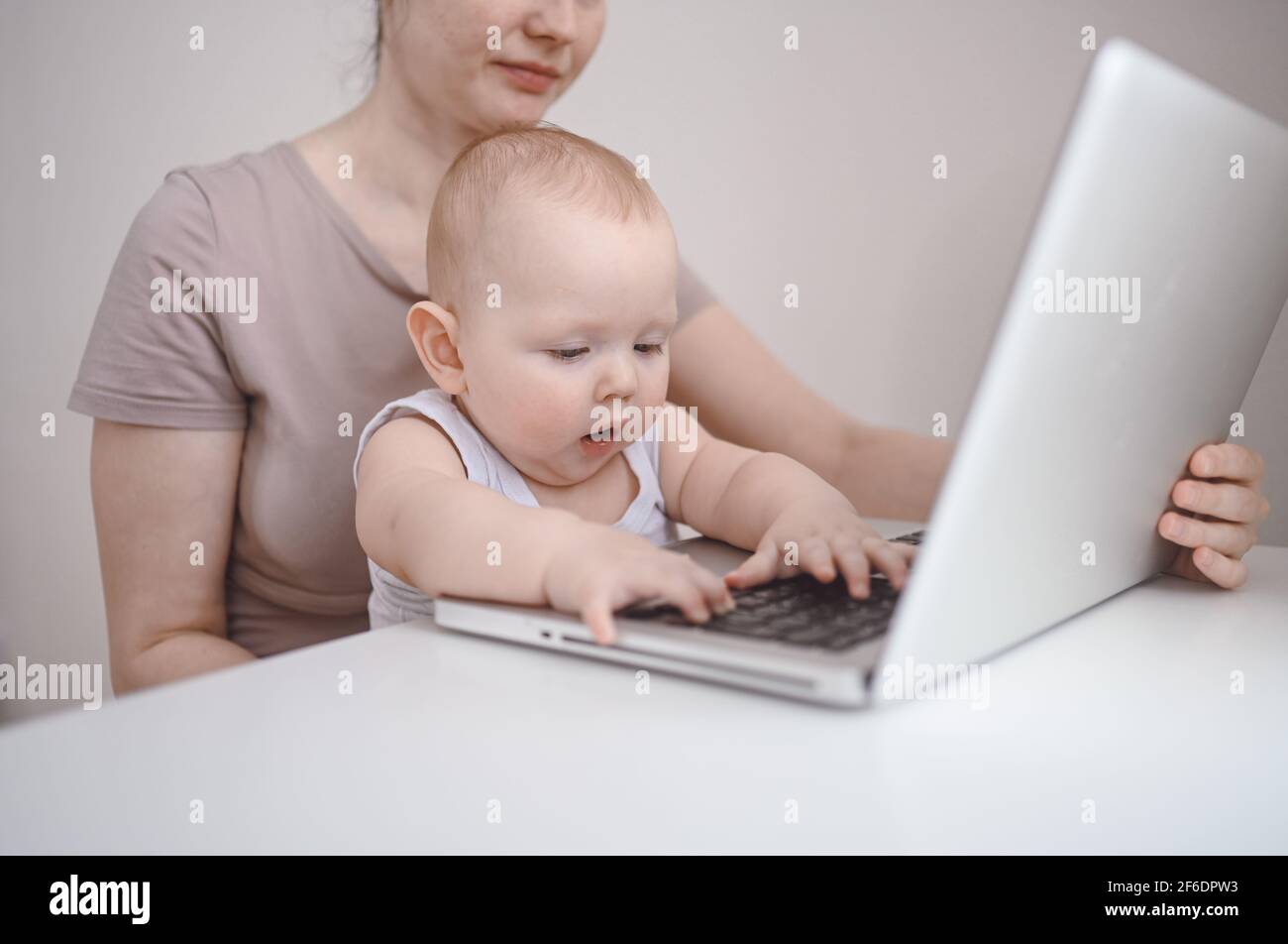 Close up portrait little baby boy funny facial expression sitting on  mother's lap studying laptop. Young mom work from home with computer. Home  office Stock Photo - Alamy