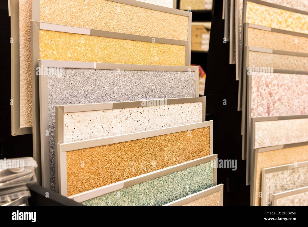 Samples of various multi-colored decorative plasters for interior design in a hardware store. Stock Photo
