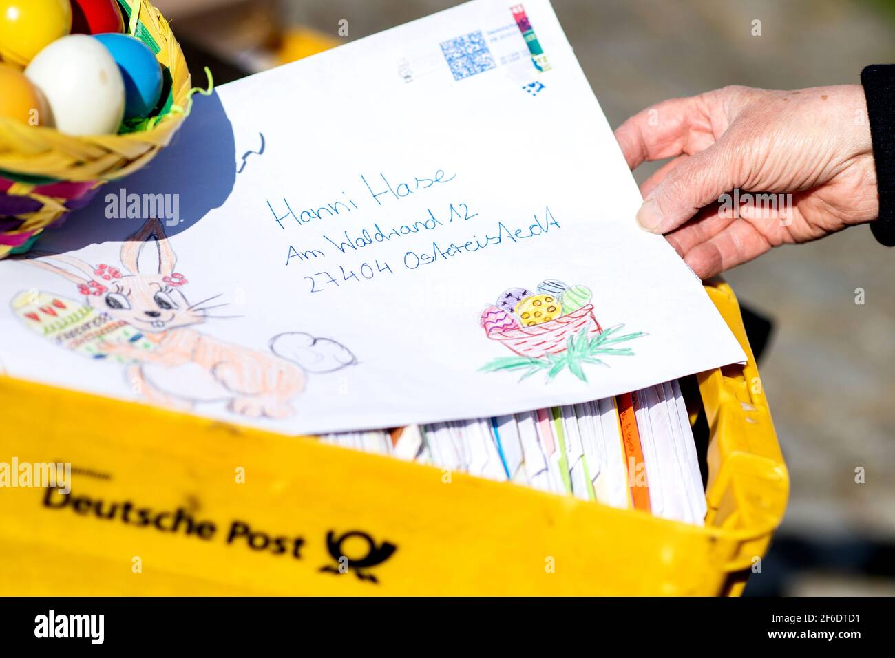 Ostereistedt, Germany. 31st Mar, 2021. Doris Kröger, an employee at the Easter post office, holds a letter written by a child to Hanni Hase, the Easter bunny. A record number of around 100,000 letters have arrived at the Easter post office in Ostereistedt this year. The letters will be answered by volunteers until next week. Credit: Hauke-Christian Dittrich/dpa/Alamy Live News Stock Photo