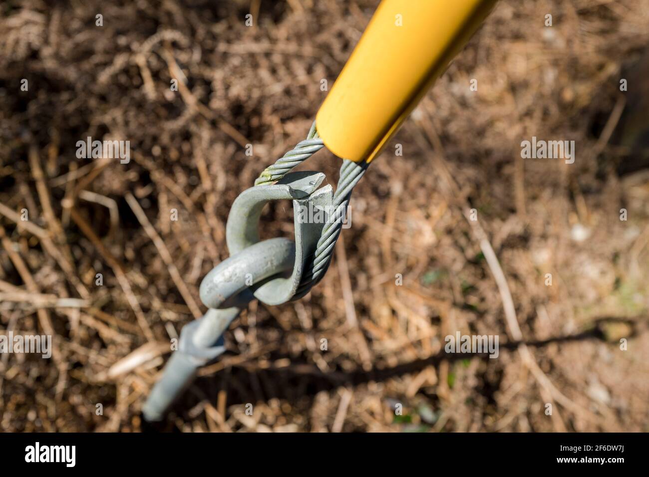Steel galvanised turnbuckle and stranded cable supporting wooden pole