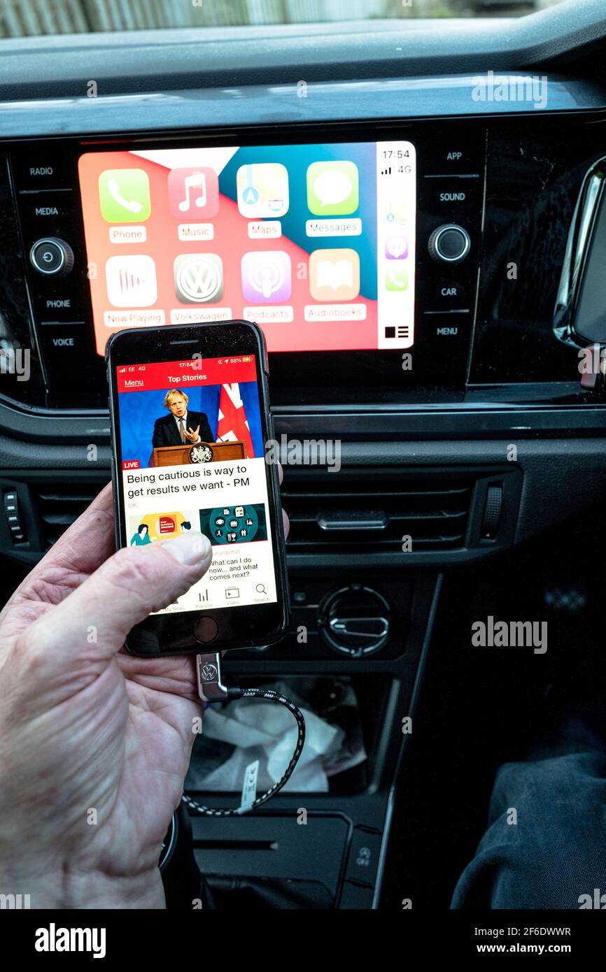 Man using his apple iphone connect too the in car entertainment and  communication unit in a VW Polo Stock Photo - Alamy