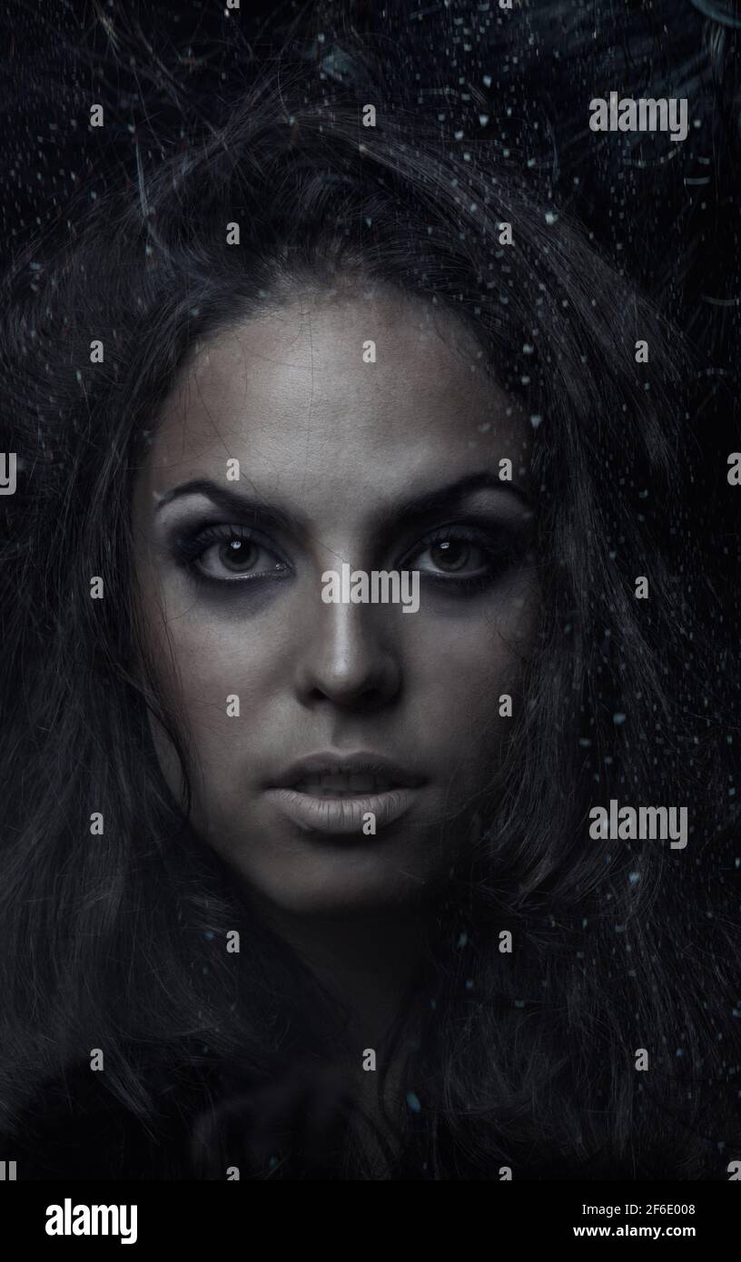 Dark witch behind the wet glass Stock Photo