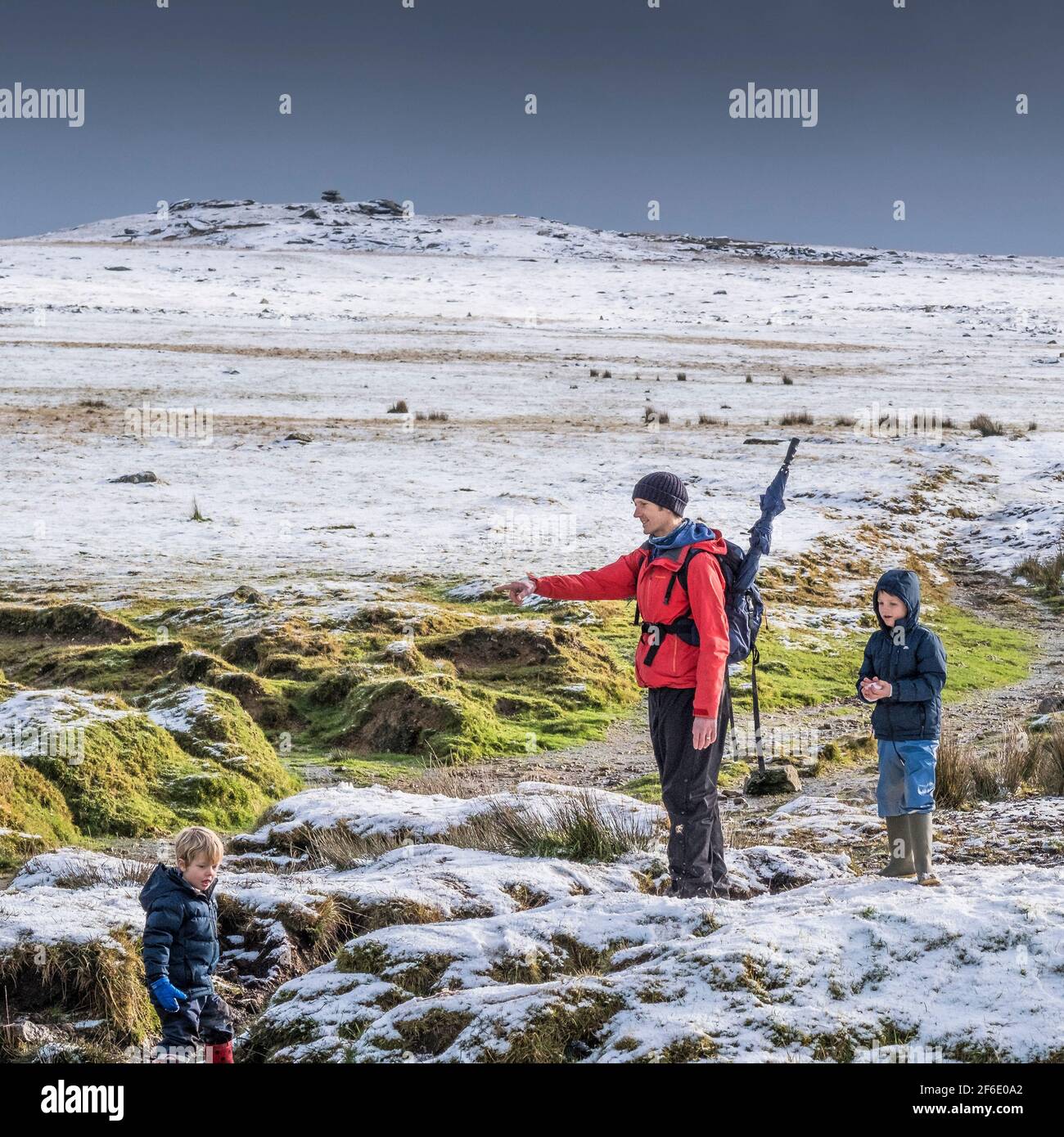 People enjoying themselves in the snow on the wild rugged Rough Tor on Bodmin Moor in Cornwall. Stock Photo