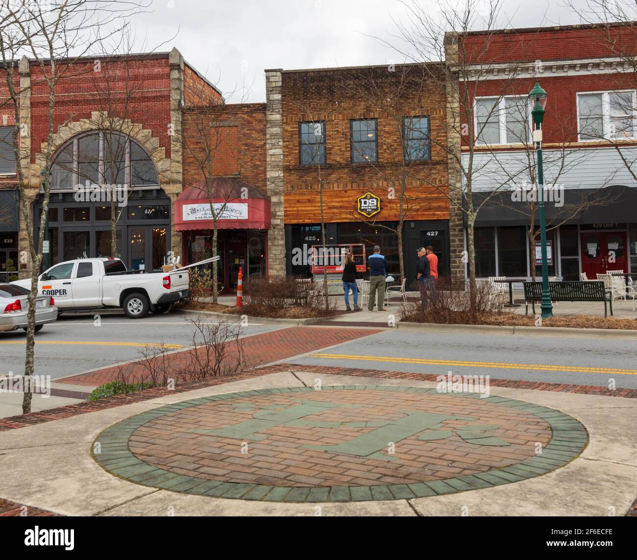 HENDERSONVILLE, NC, USA--23 MARCH 2021: Four people talking in front of ongoing construction at the D9 Brewing Company on Main Street. Stock Photo