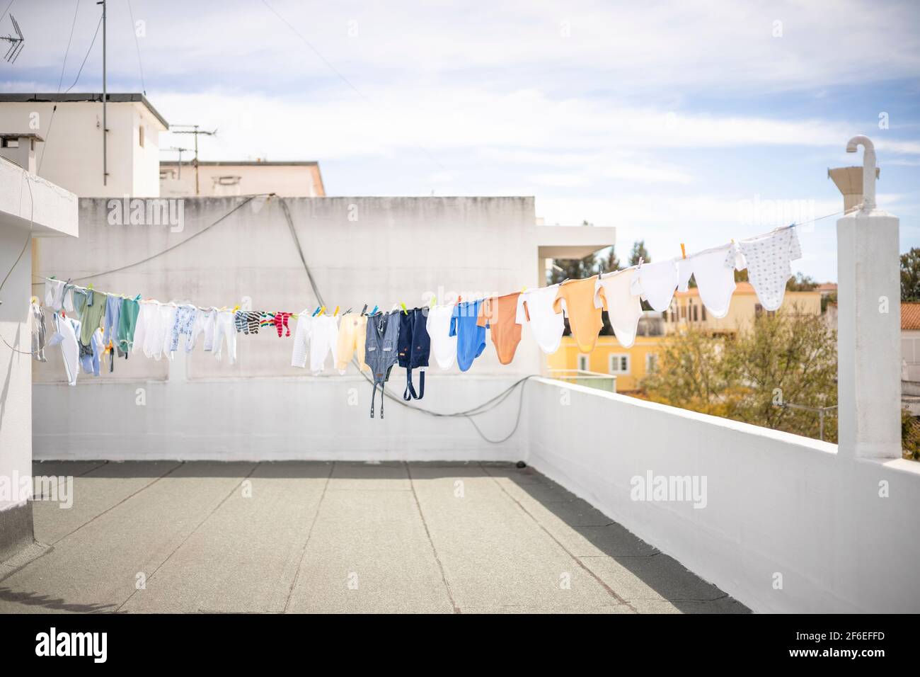 Drying a lot of baby clothes on the roof top in the city Stock Photo