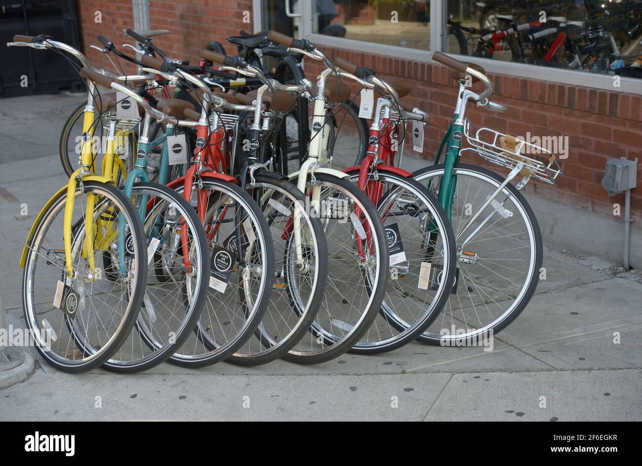 a row of colourful bicycles outside a vendor's shop Stock Photo