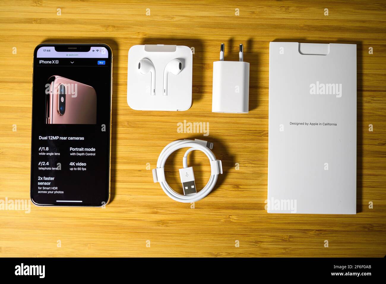 View from above at latest Apple Computers iPhone XS gold color 256GB  smartphone featuring all contents of the package accesories - wooden table  Stock Photo - Alamy