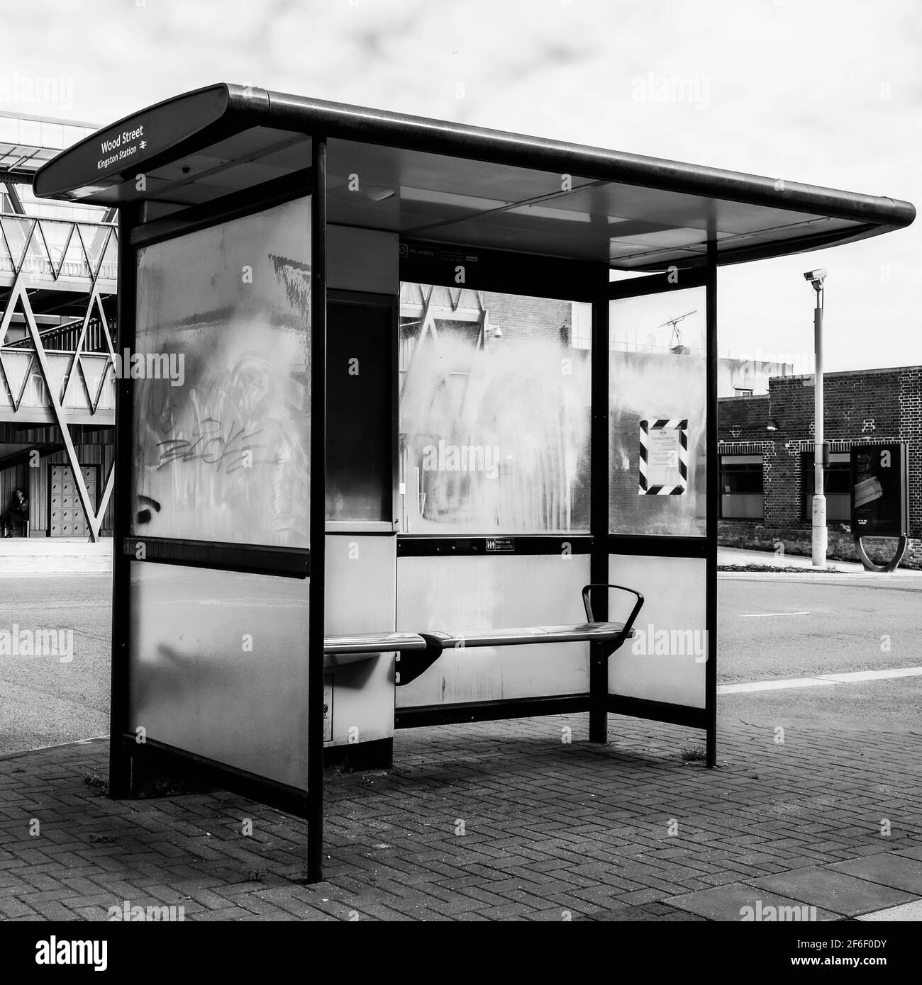 Black And White Image Of A Modern Public Bus Stop Shelter Adn Seating With No People Stock Photo