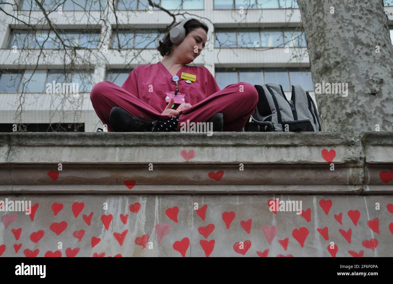 An NHS Nurse Sits  Above London's National Covid Memorial Wall. Stock Photo