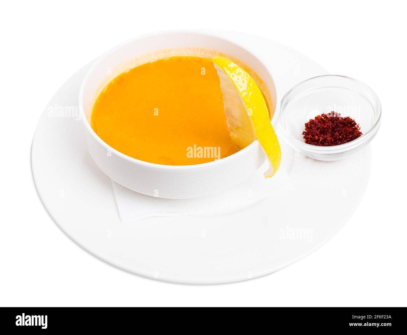 Lentil soup cream with lemon slice and dried minced paprika spice. Isolated on a white background. Stock Photo