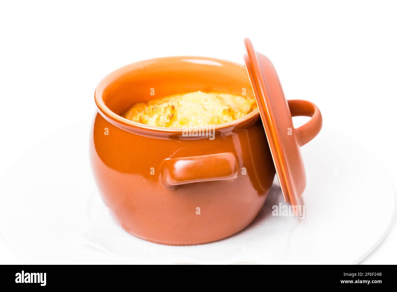 Pork sausages on crock pot covered with cheese. Isolated on a white