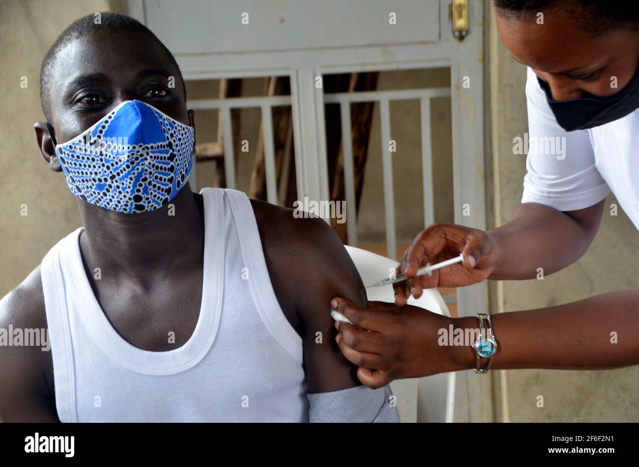 Kampala, Uganda. 31st Mar, 2021. A teacher receives a dose of COVID-19 vaccine at a health center in Kampala, capital of Uganda, March 31, 2021. Uganda launched the first phase of COVID-19 vaccination campaign on March 10, targeting high risk groups in the east African country. The ministry of health targets to vaccinate more than 21.9 million people who face the highest risk of the infection, which include health workers, teachers, security personnel, elderly and those with underlying medical conditions. Credit: Nicholas Kajoba/Xinhua/Alamy Live News Stock Photo