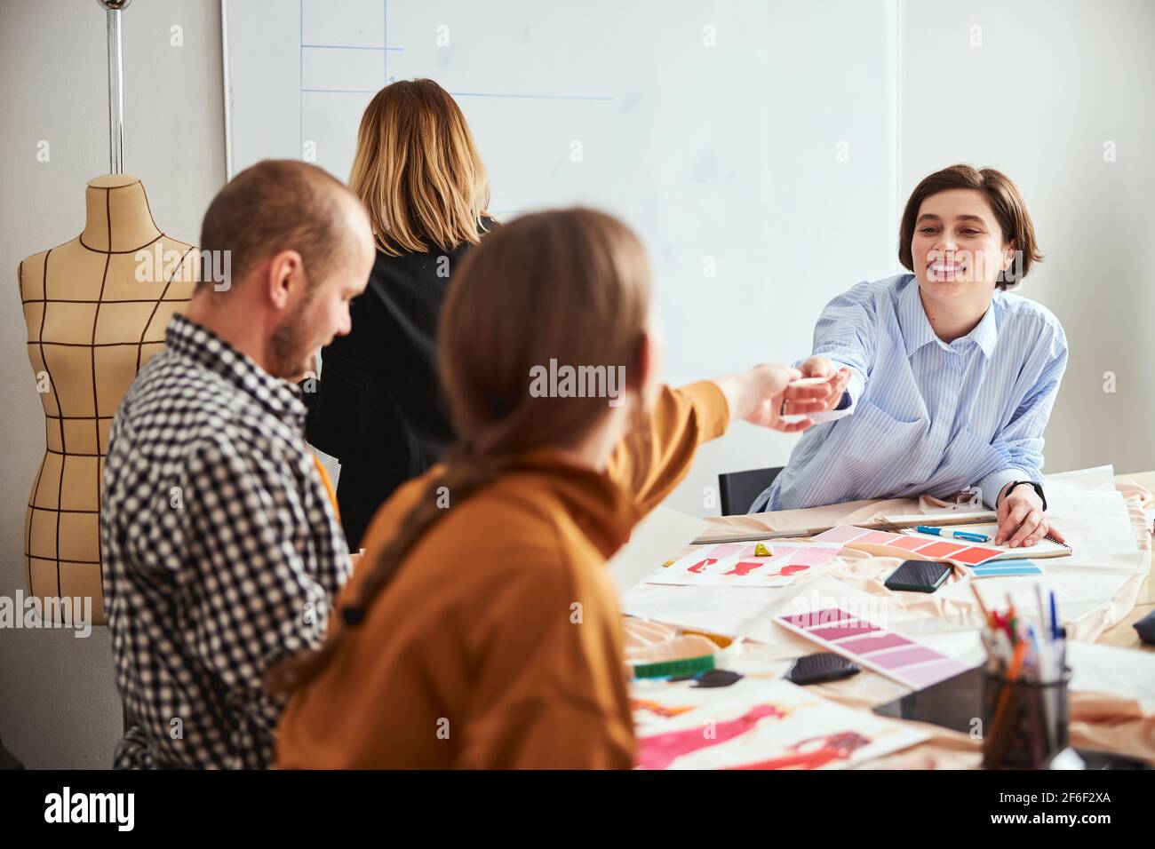 Positive designer sharing notes with her colleagues stock photo alamy