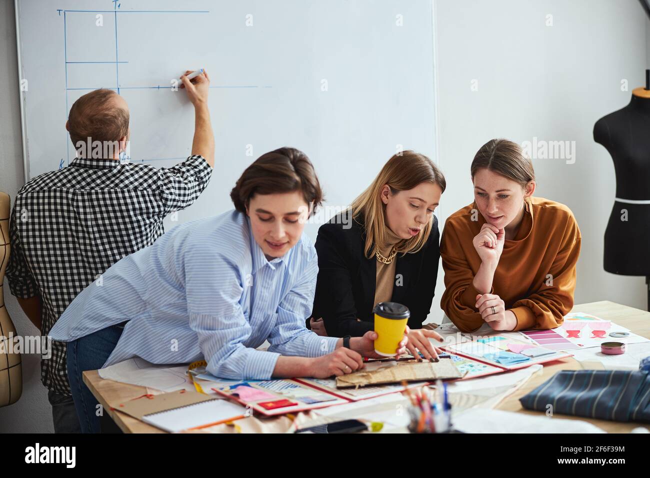 Confident creative fashion designers working in team Stock Photo