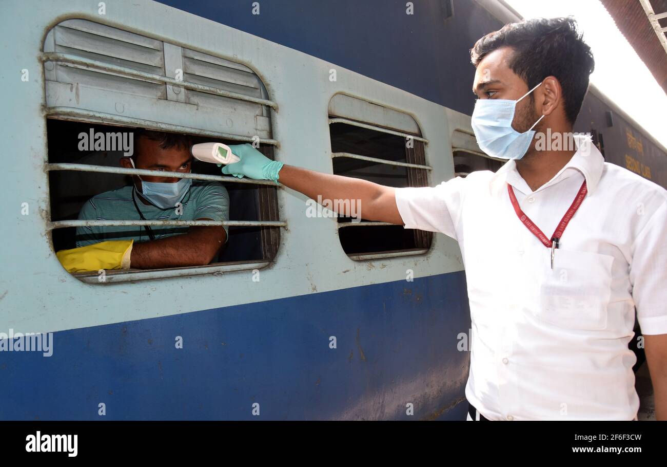 Patna, Indian state of Bihar. 31st Mar, 2021. A health worker takes thermal screening of a passenger at a railway station in Patna, capital of eastern Indian state of Bihar, March 31, 2021. India's COVID tally rose to 12,149,335 on Wednesday as 53,480 new cases were reported from across the country, according to the latest figures released by the federal health ministry. Credit: Str/Xinhua/Alamy Live News Stock Photo