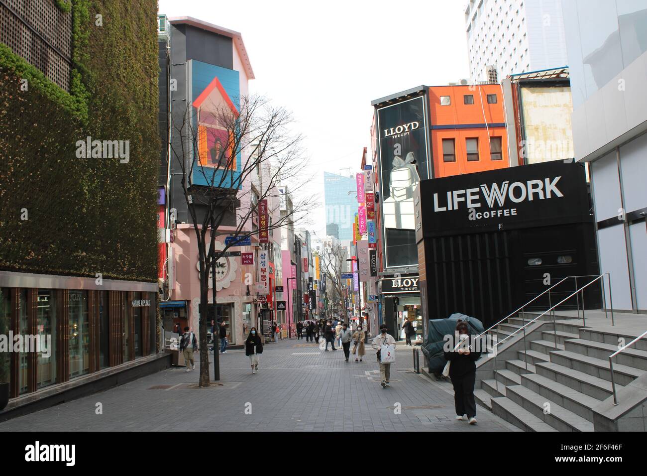 People walking down busy commercial avenue in Myeongdong, Seoul Stock Photo