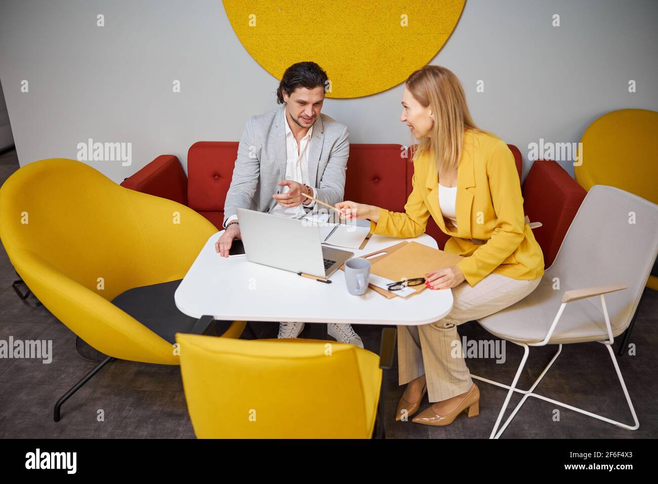 Two friendly people having pleasant conversation in office Stock Photo
