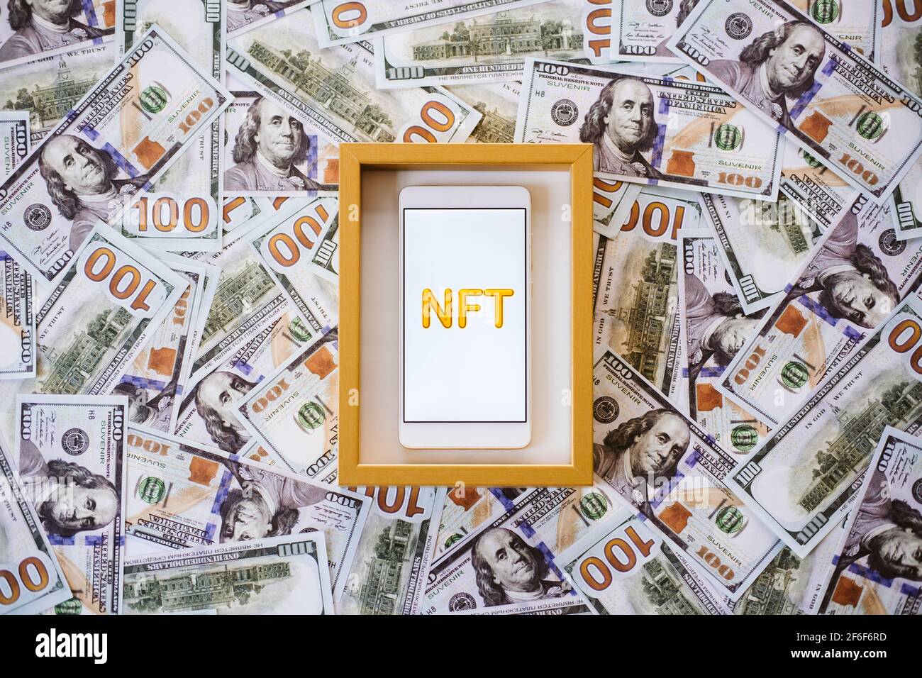 Non-fungible token NFT, crypto art, digital art, new type of  cryptorurrency. Cell phone with golden NFT text in golden frame as art  object on dollars Stock Photo - Alamy