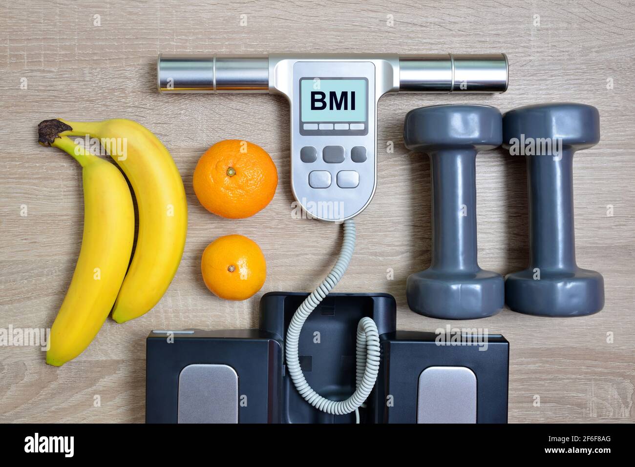 https://c8.alamy.com/comp/2F6F8AG/body-mass-index-scale-with-fruits-and-dumbbells-on-wooden-boardhealthy-lifestyle-concept-2F6F8AG.jpg