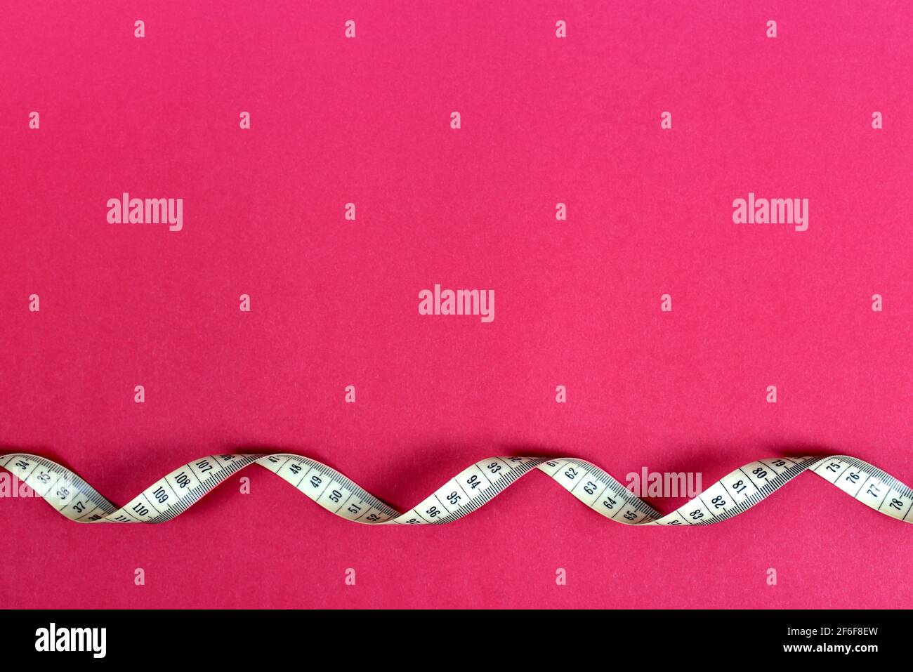 Measuring tape on a pink background with copy space Stock Photo - Alamy