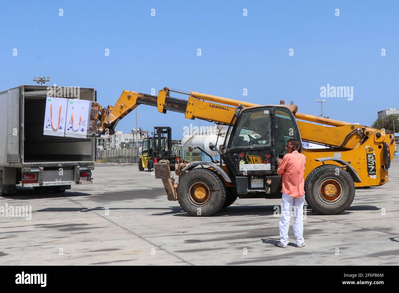 Aden, Yemen. 31st Mar, 2021. Airport staff members unload boxes containing doses COVID-19 vaccine at the airport of Aden. Credit: Wail Shaif/dpa/Alamy Live News Stock Photo