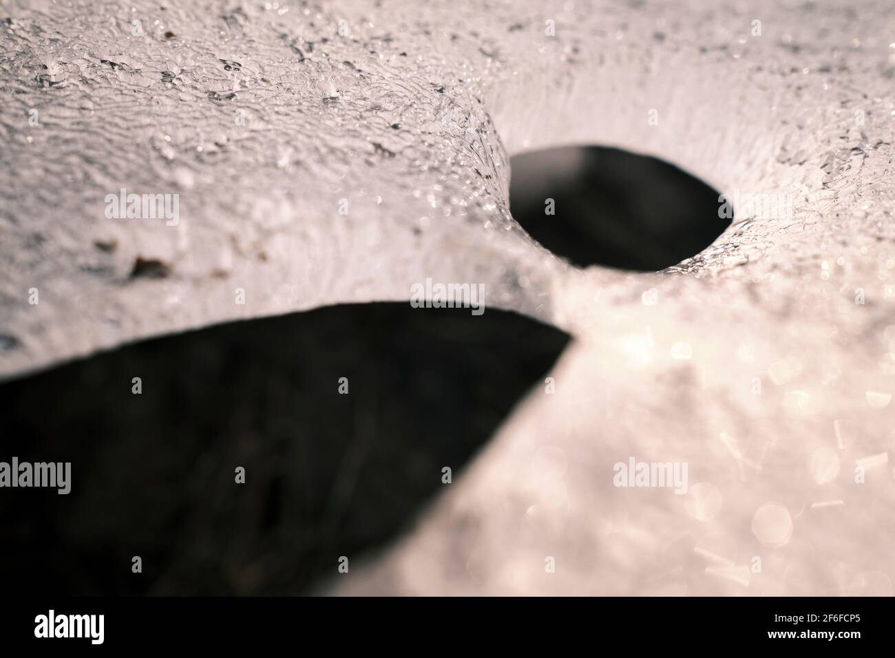 Melted holes in ice in closeup Stock Photo Alamy