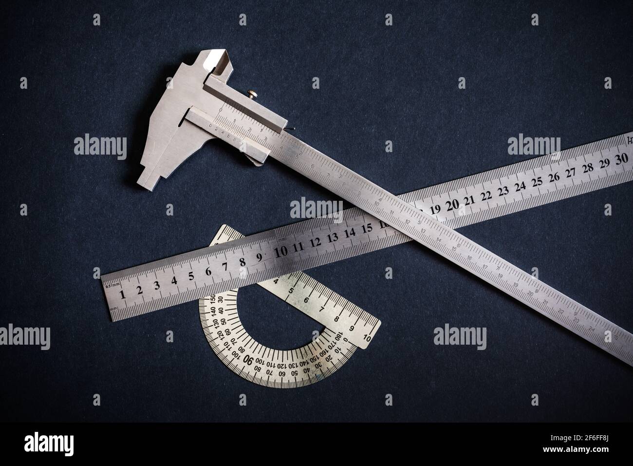 Goniometer and Ruler and Vernier caliper three types on dark grey-black patterns background. Non-color, monochrome black and white photo. Stock Photo