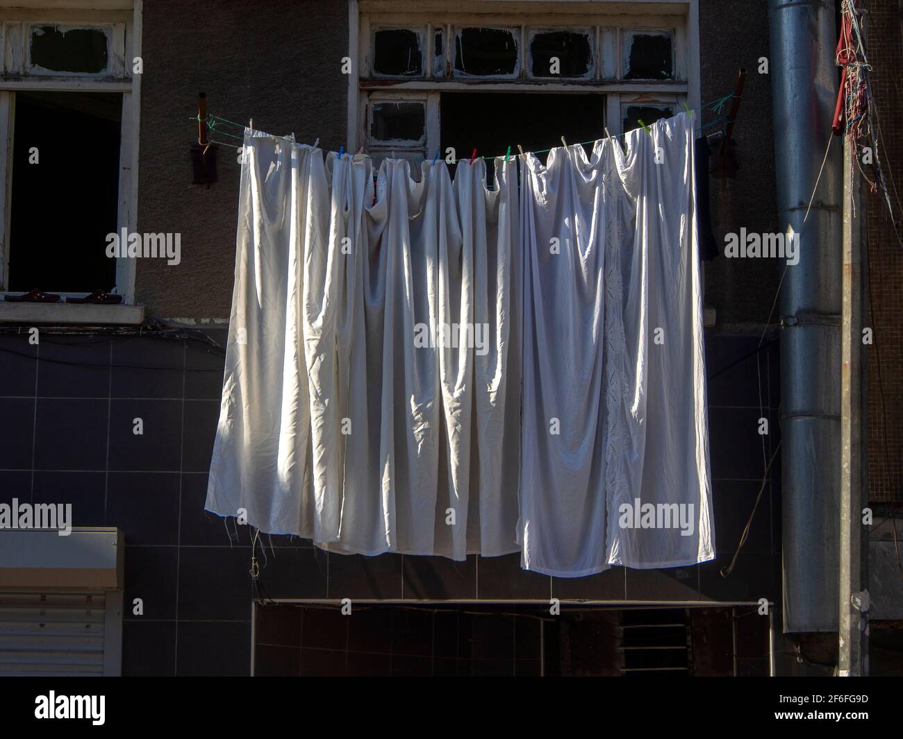 white clothes hanging on a rope in the street Stock Photo