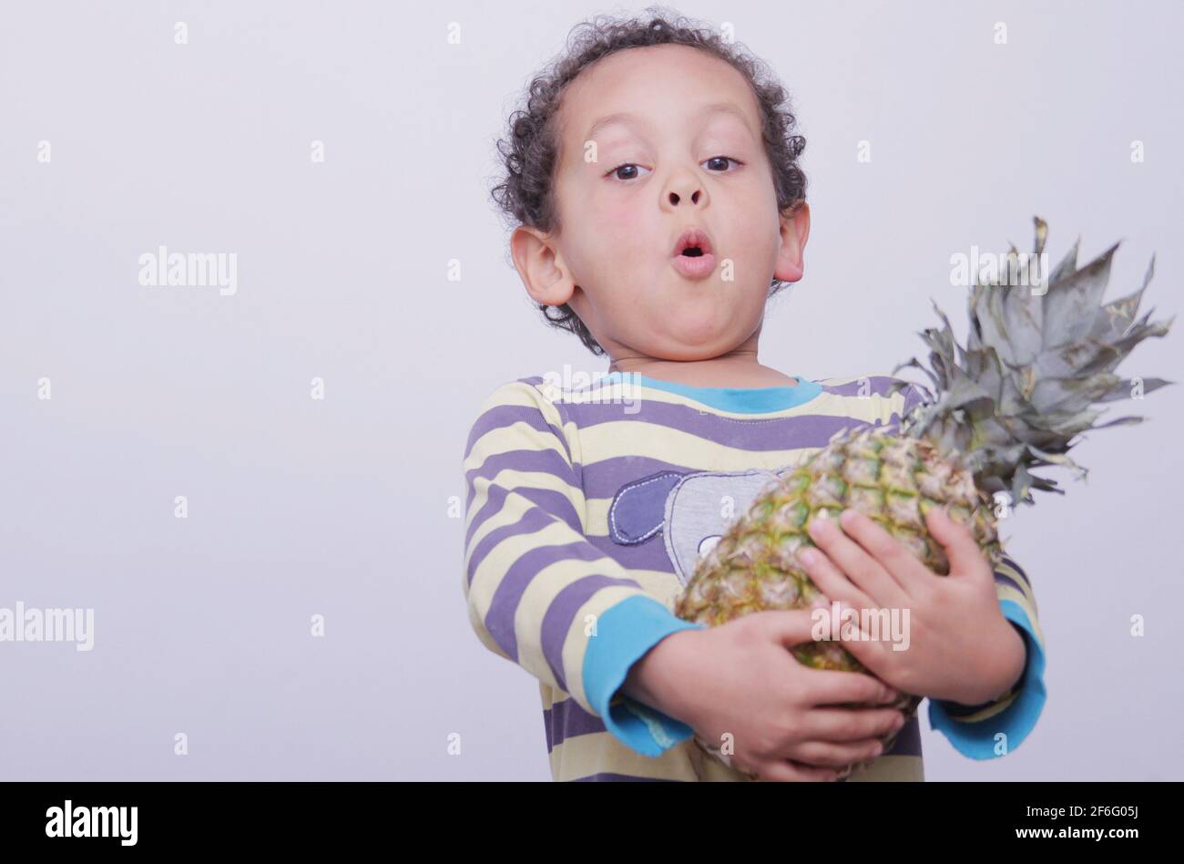 little boy holding a pineapple on white background stock image stock photo Stock Photo