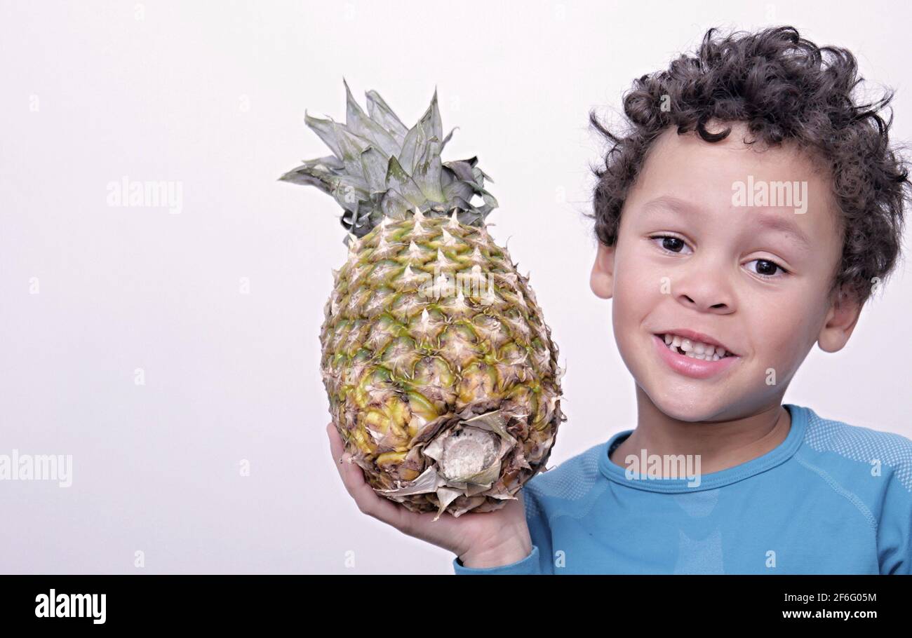 little boy holding a pineapple on white background stock image stock photo Stock Photo