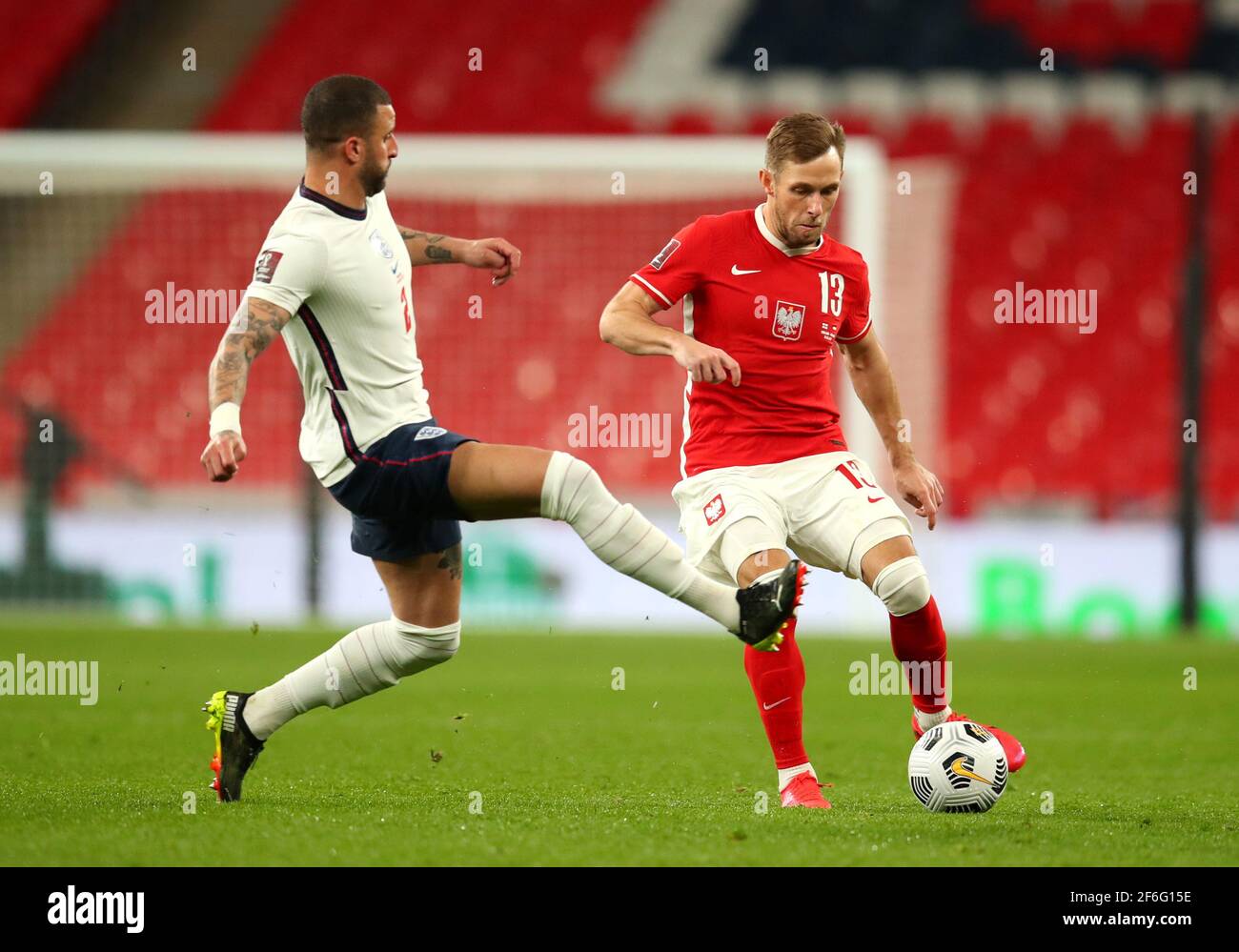 England's Kyle Walker (left) and Poland's Maciej Rybus battle for the ball during the 2022 FIFA World Cup Qualifying match at Wembley Stadium, London. Picture date: Wednesday March 31, 2021. Stock Photo