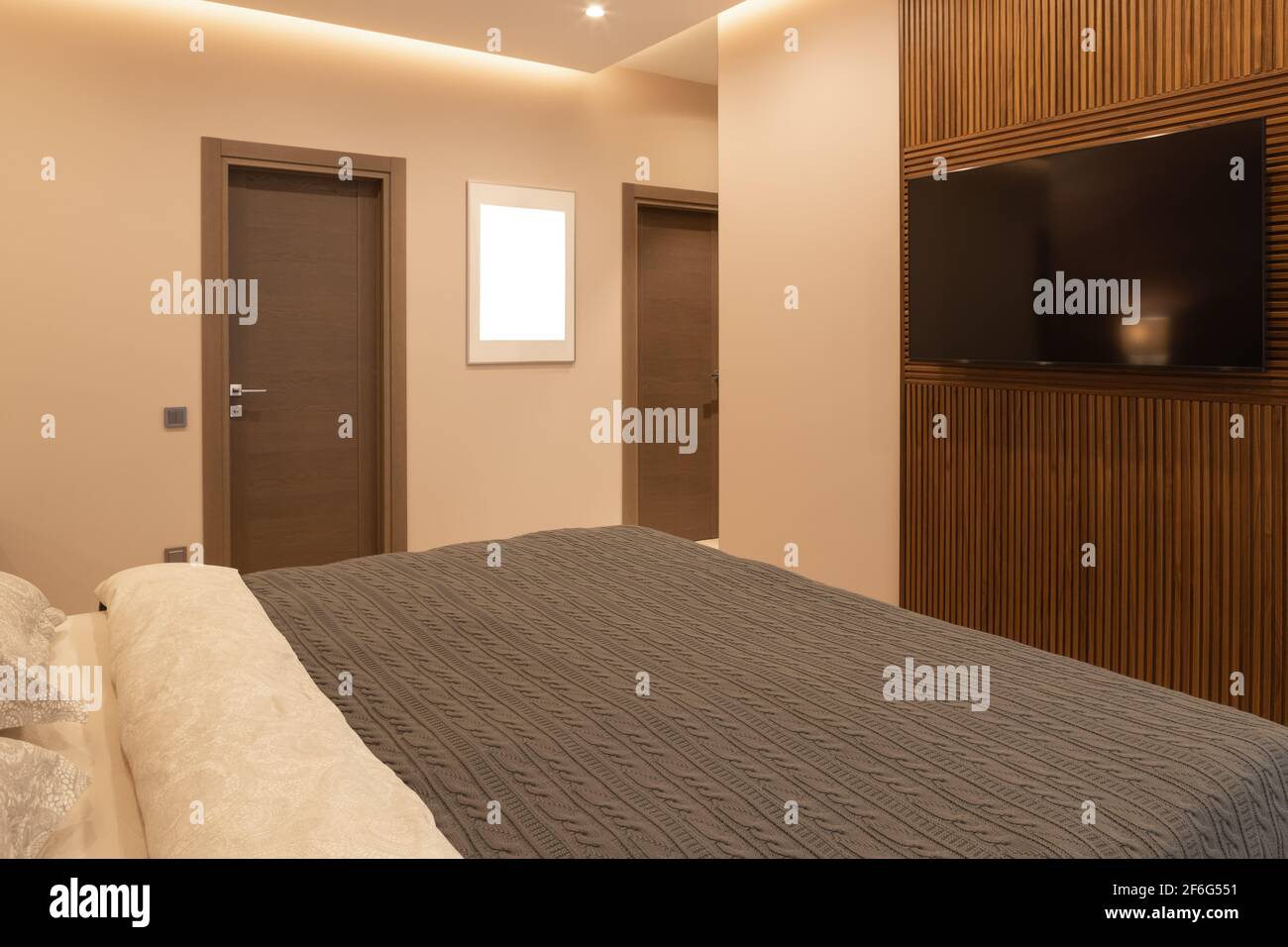 Modern bedroom in apartment, in neutral earthy tones. Double bed. Photo