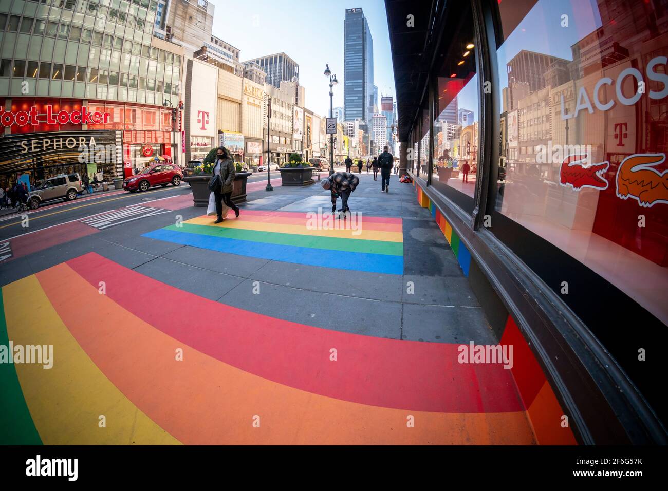 New York, USA. 30th Mar, 2021. A worker removes a vinyl rainbow from in  front of Macy's department store on Tuesday, March 30, 2021. The display  was part of a promotion for