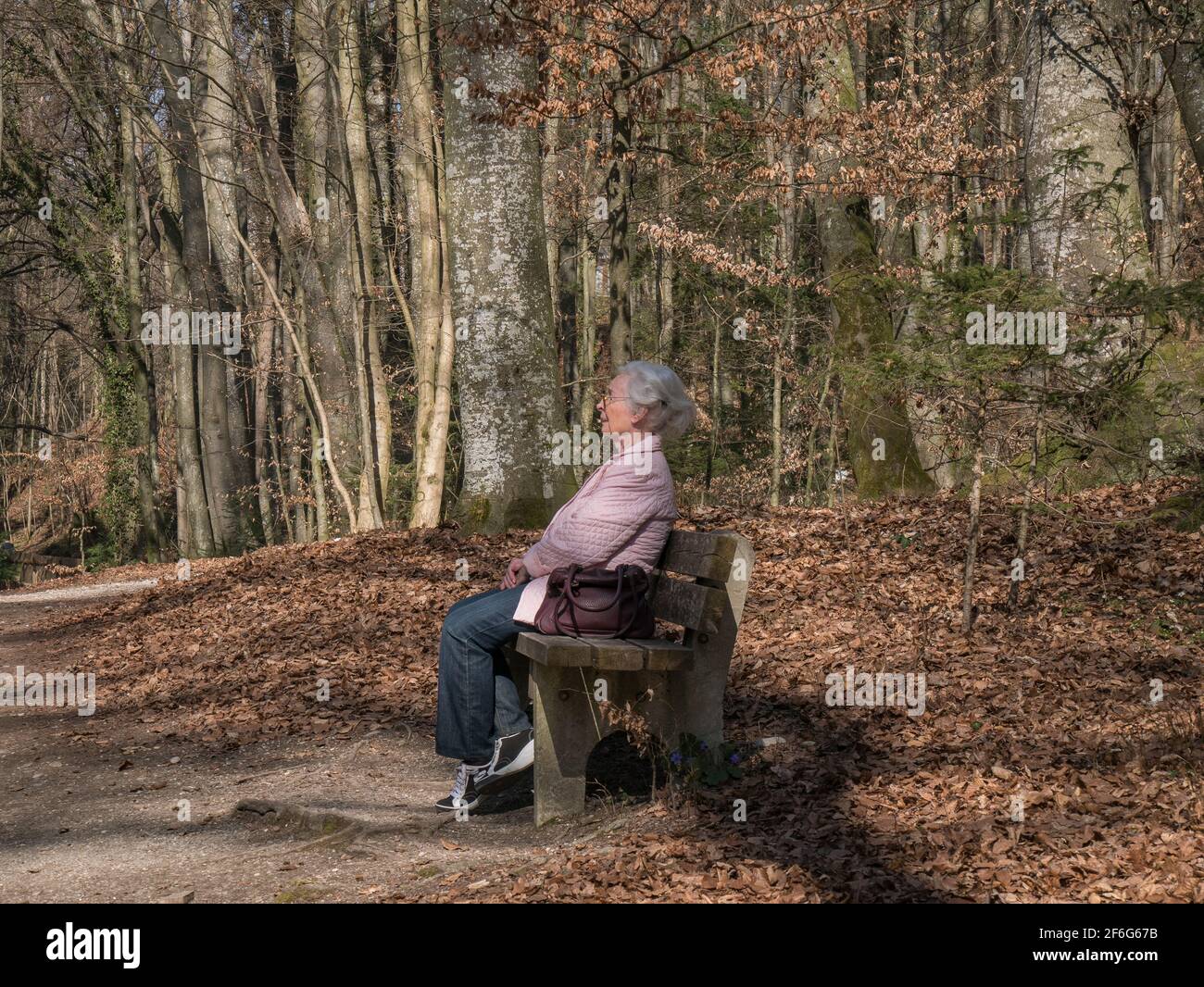 Lonely senior woman sitting in the park Stock Photo