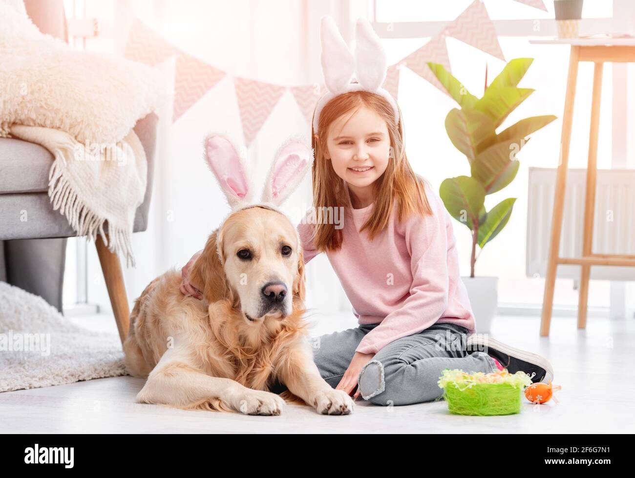 Little girl with golden retriever dog at Easter Stock Photo