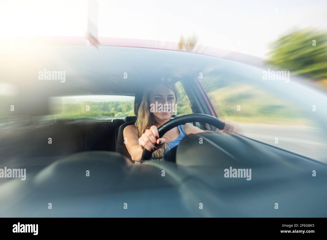 Happy beautiful woman is driving a red car Stock Photo - Alamy