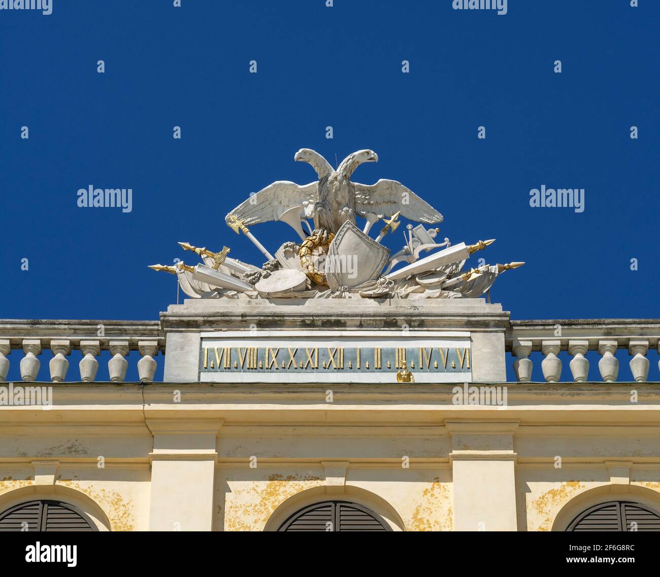 Schonbrunn Palace Clock: Facing the garden is an elaborate double eagle decorated linear clock high above the central garden door of this Vienna landmark. Stock Photo