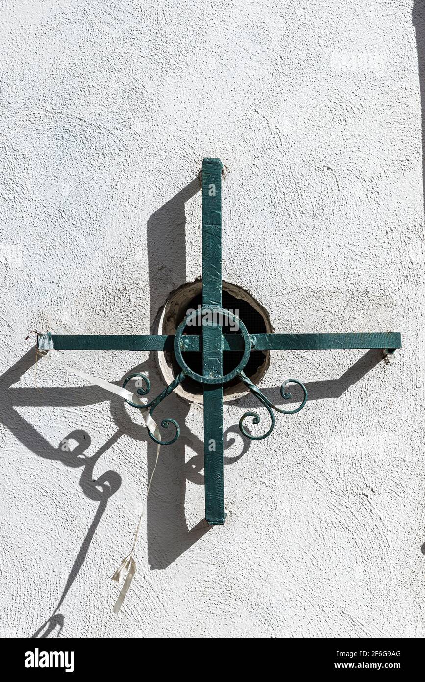 Wrought iron fence in the shape of a cross covering a small window on the church of Santa Maria Donnaregina Nuova in Naples, Italy Stock Photo