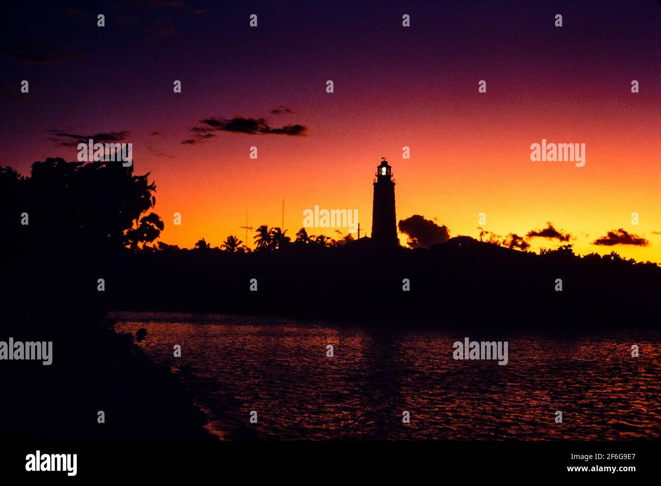 Hopetown Lighthouse in Afterglow: Standing high just inside Hopetown harbour's entrance the Lighthouse stands in silhouette lit by the afterglow of a firey sunset.  b78.33 Stock Photo