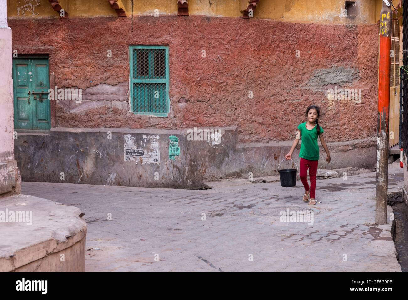 Young girls carrying water in the streets of the blue city of Jodhpur in Rajasthan, India Stock Photo