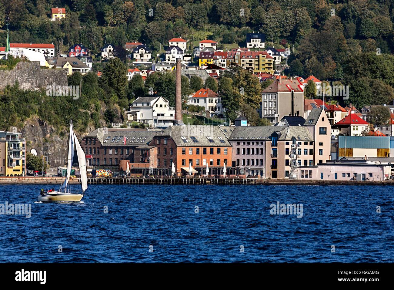 The old sardine factory USF at Verftet,  Bergen, Norway.  Small sailboat, sail number N1760 Stock Photo