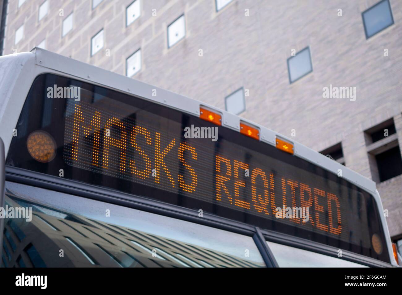 lighted message on the header of city bus reading Masks Required covid 19 Stock Photo