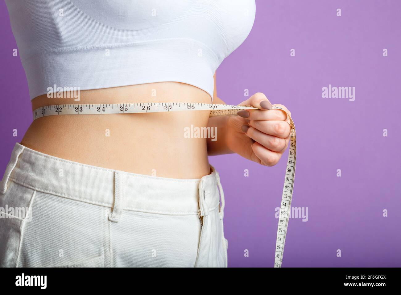 young girl belly waist measurement with tape measure and measure in  centimeters Stock Photo - Alamy