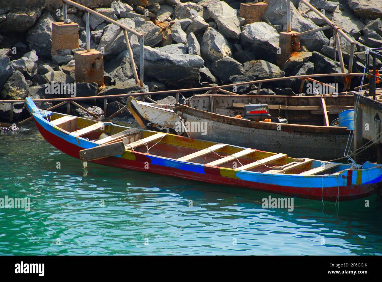 Two fishing boats lie on warm waters at a rocky shore in Ghana, West Africa. Stock Photo