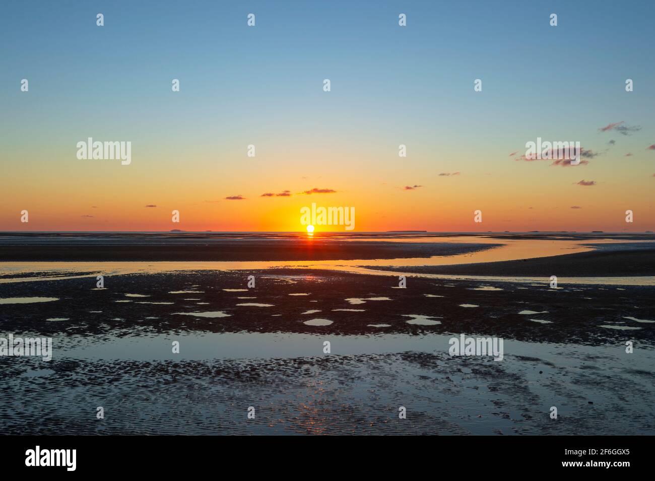 Sun on the horizon at sunrise over Carmila Beach , near Sarina, Queensland, QLD, Australia Stock Photo