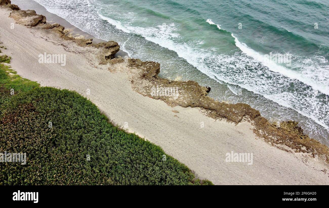 Aerial View of Natural Florida Beach with Waves Crashing Against Rocks Stock Photo