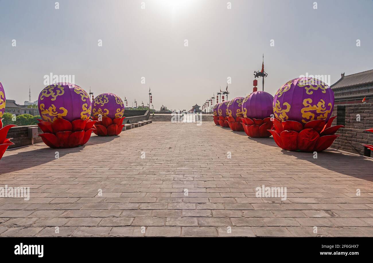 Xian, China - April 30, 2010: Huancheng City Wall. Year of the tiger  display. Tows of gold-purple inflatable large spheres set in red cups on  rampart Stock Photo - Alamy